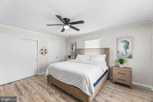 a bedroom with a bed a dresser and with window