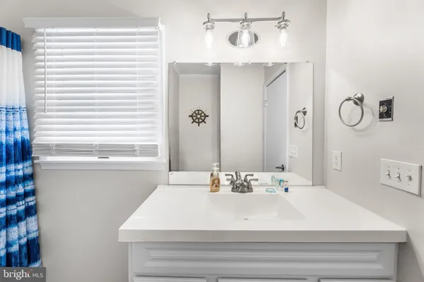 a bathroom with a sink shower and a mirror