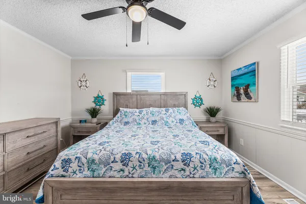 a bedroom with a large bed chandelier and a window