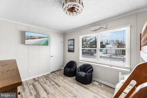 a bedroom with a bed a dresser and a window