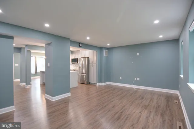 a view of a big room with wooden floor and windows