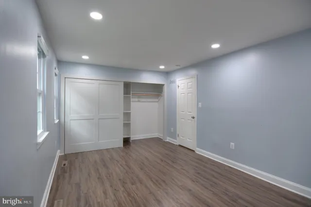 an empty room with wooden floor and entrance