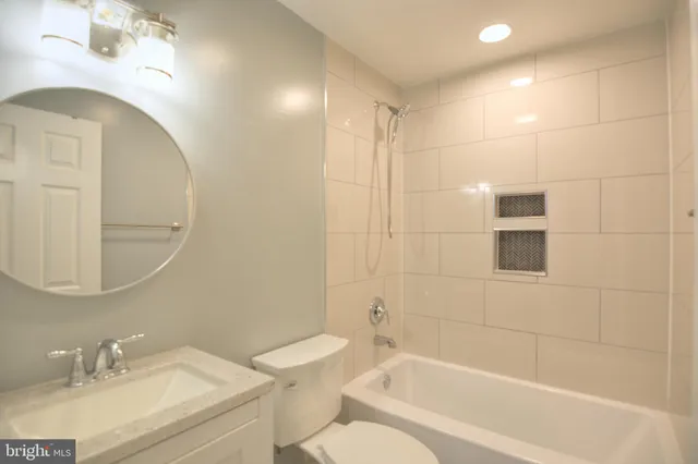 a bathroom with a granite countertop sink a toilet and shower