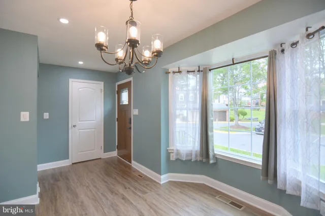 a view of a livingroom with a large window wooden floor and windows
