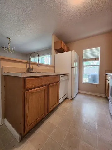 a kitchen with white cabinets and sink