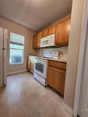 a kitchen with a stove top oven sink and cabinets