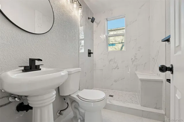 a bathroom with a sink a toilet and a mirror