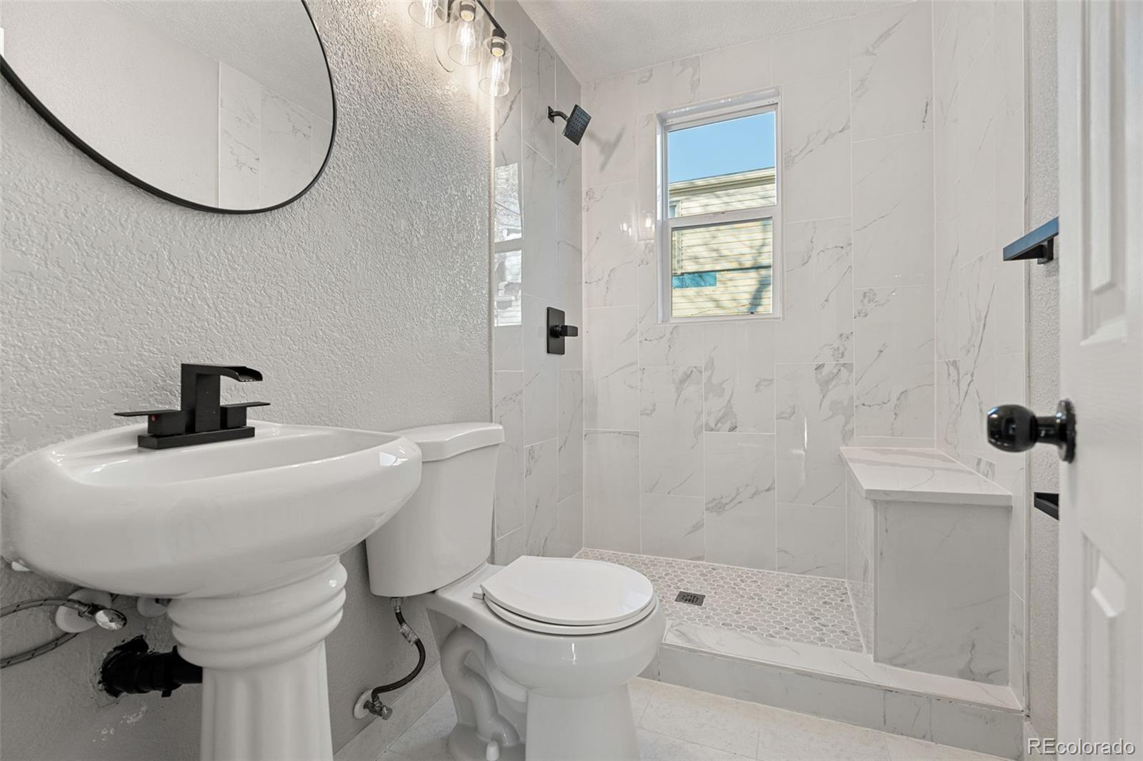 1141 Dayton Street Aurora, CO 80010 - Photo 11 of 23 a bathroom with a sink a toilet and a mirror