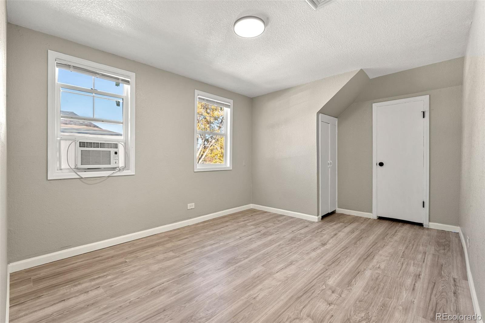 1141 Dayton Street Aurora, CO 80010 - Photo 15 of 23 a view of an empty room with wooden floor and a window