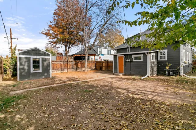 a backyard of a house with large trees and brick walls