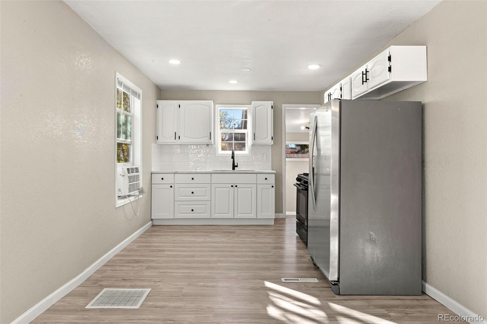 1141 Dayton Street Aurora, CO 80010 - Photo 6 of 23 a view of a kitchen with refrigerator and wooden floor