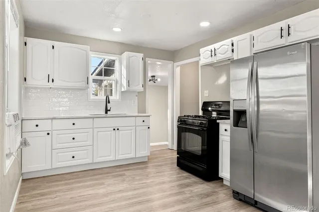 a kitchen with white cabinets and stainless steel appliances