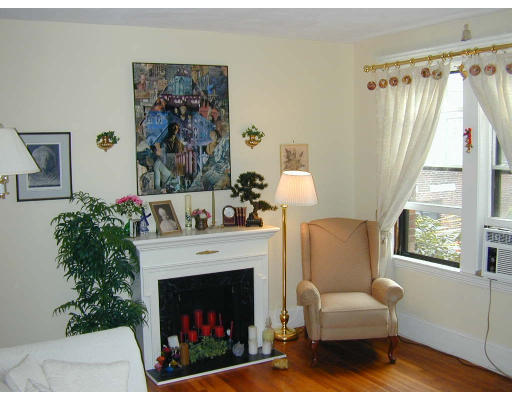 a living room with a furniture a fireplace and a large window