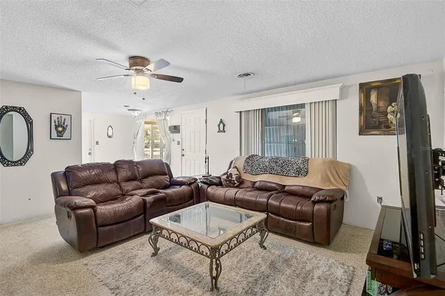 a living room with furniture ceiling fan and a window