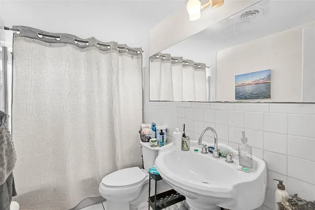 a bathroom with a sink a toilet and shower curtain