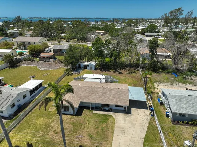 an aerial view of a house with swimming pool and large trees