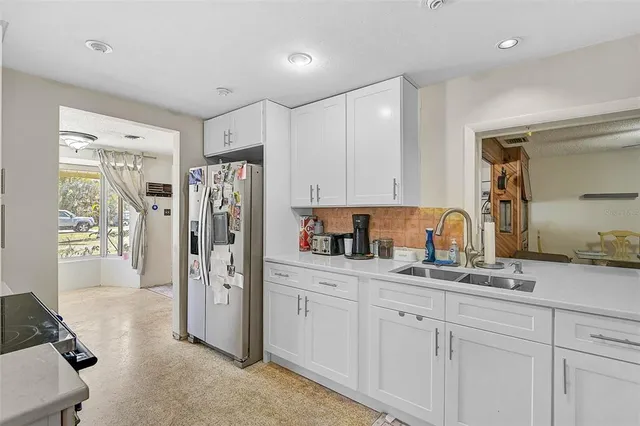 a kitchen with stainless steel appliances white cabinets and a refrigerator