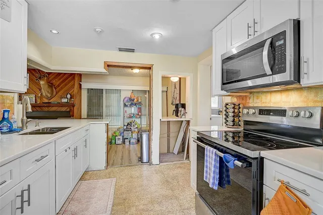 a kitchen with stainless steel appliances a stove microwave and sink