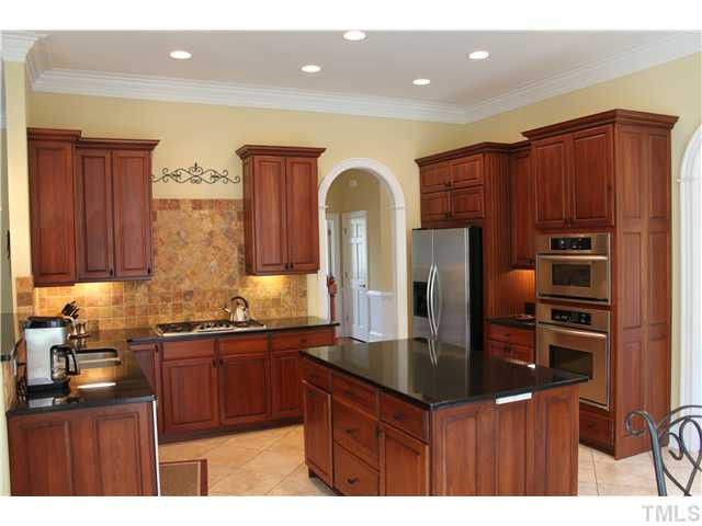 2108 Tulare Court Raleigh, NC 27612 - Photo 4 of 25 Awesome kitchen !!! large island granite decorative tile back splash raised panel cherry cabinets with Kitchen Aid appliances Kitchen