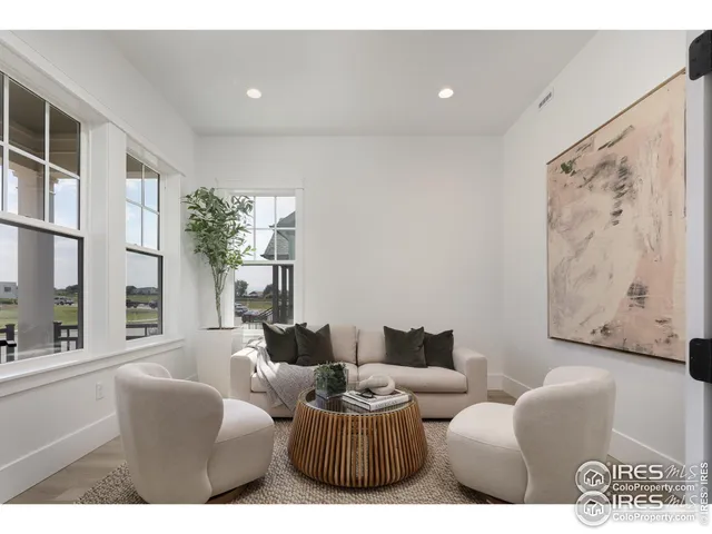 a living room with furniture a large window and a potted plant