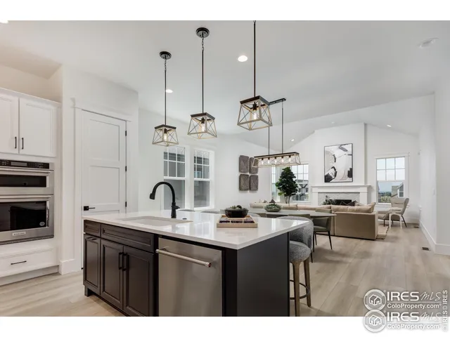 a kitchen with kitchen island granite countertop a sink cabinets and stainless steel appliances