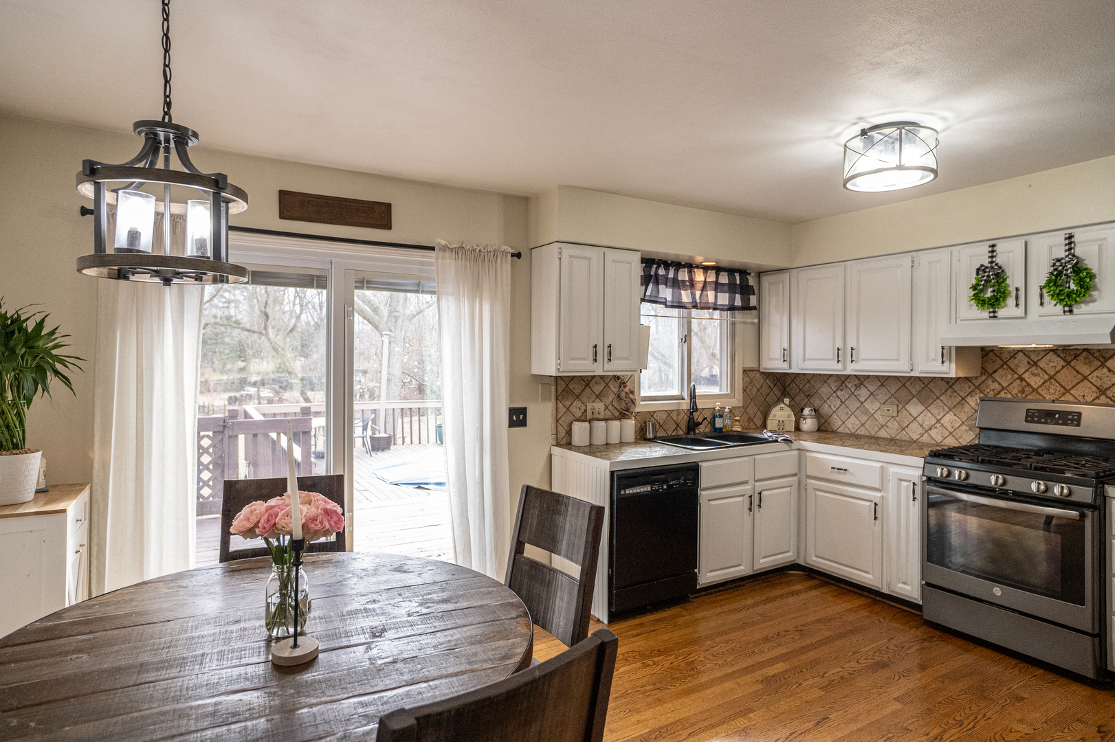 1403 West Beach Road Waukegan, IL 60087 - Photo 13 of 59 a kitchen with stainless steel appliances granite countertop a stove top oven a refrigerator a dining table and chairs with wooden floor