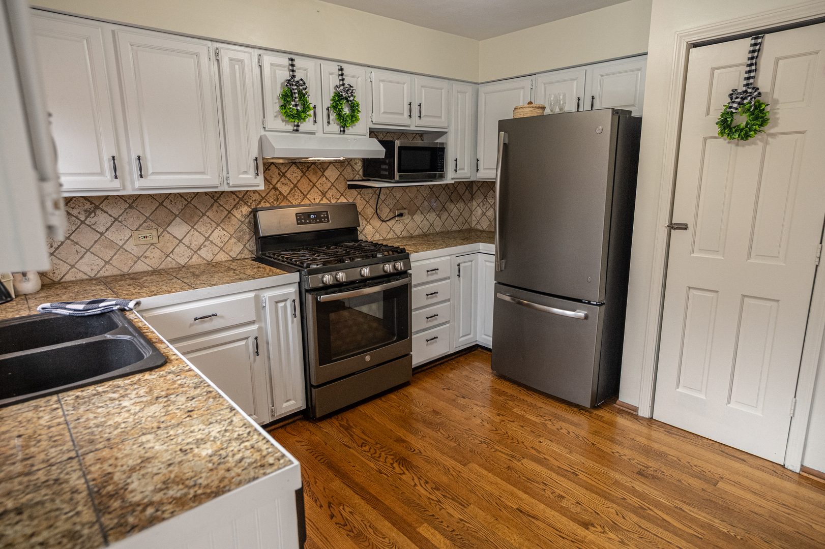 1403 West Beach Road Waukegan, IL 60087 - Photo 14 of 59 a kitchen with stainless steel appliances granite countertop a refrigerator stove and sink
