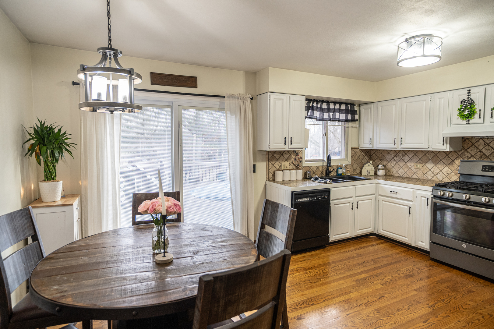 1403 West Beach Road Waukegan, IL 60087 - Photo 19 of 59 a kitchen with stainless steel appliances granite countertop a stove a refrigerator a dining table and chairs