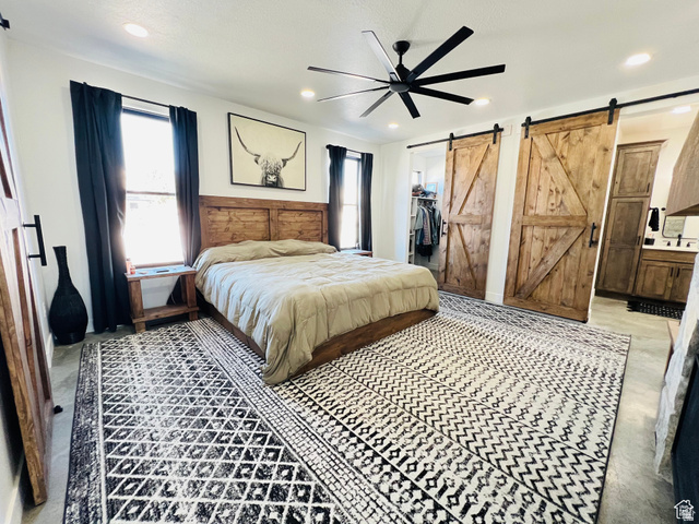 100 Whit Lane Georgetown, ID 83239 - Photo 28 of 76 Bedroom featuring a barn door, a walk in closet, a ceiling fan, multiple windows, and recessed lighting