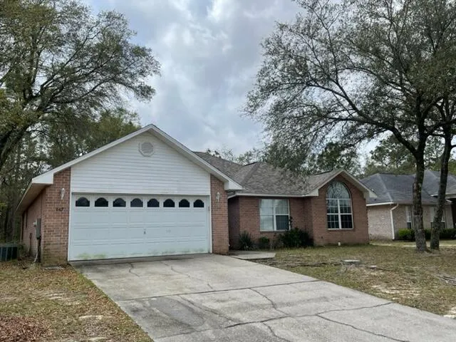 a view of a house with a yard and large tree