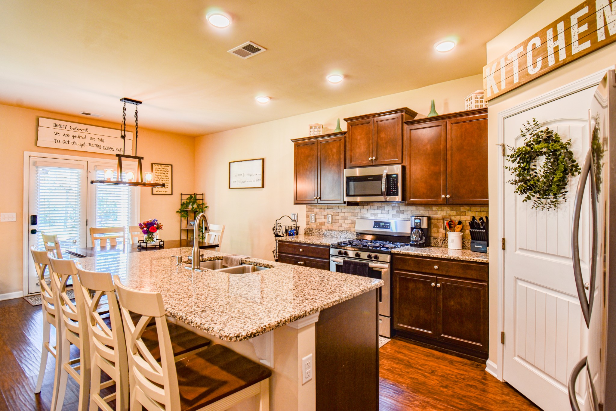 742 Prominence Road Columbia, TN 38401 - Photo 10 of 33 a kitchen with stainless steel appliances kitchen island granite countertop a refrigerator a stove top oven a sink dishwasher and wooden cabinets with wooden floor