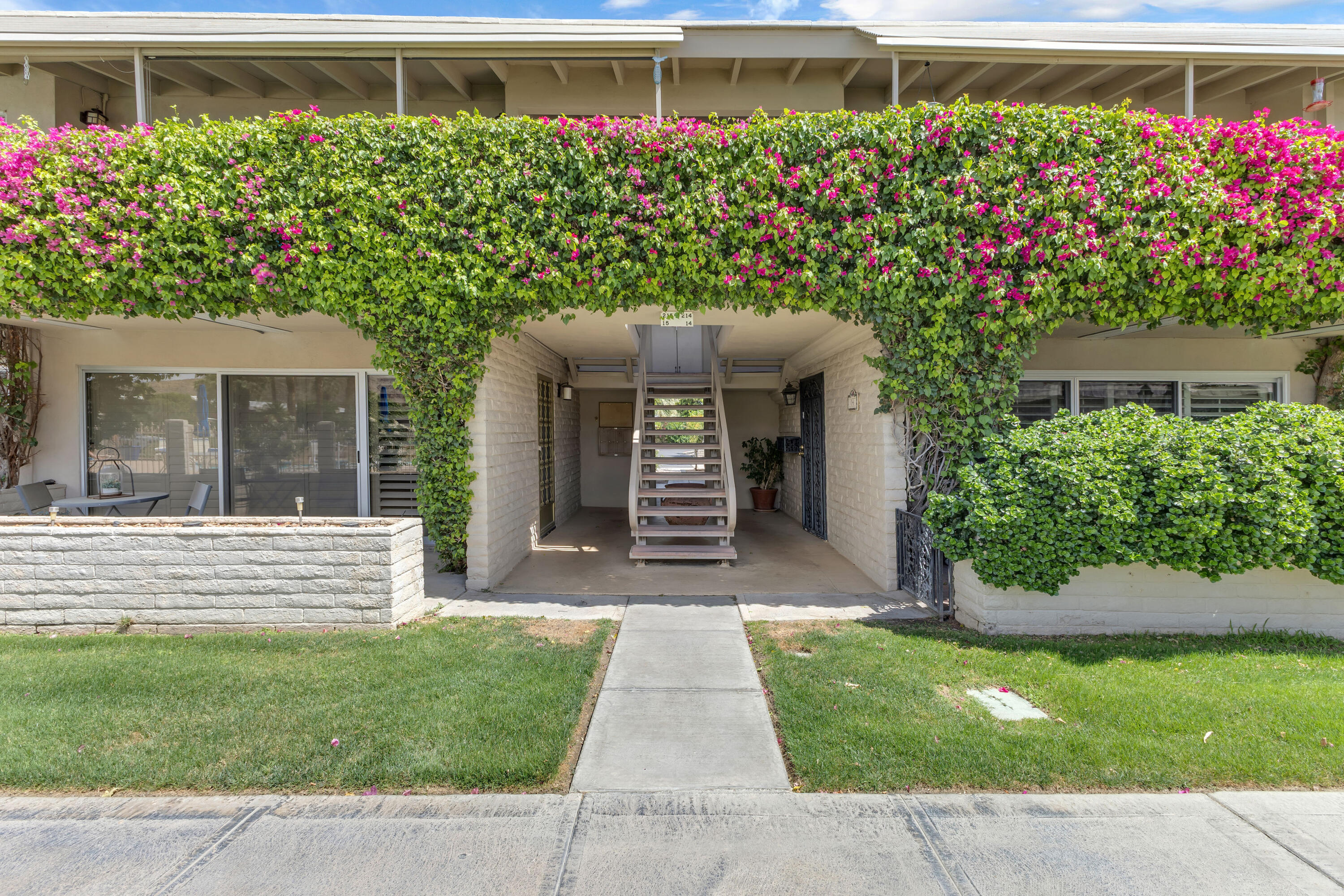 69850 Hwy 111 Rancho Mirage Ca, Unit 14 Rancho Mirage, CA 92270 - Photo 1 of 56 a front view of a house with a garden