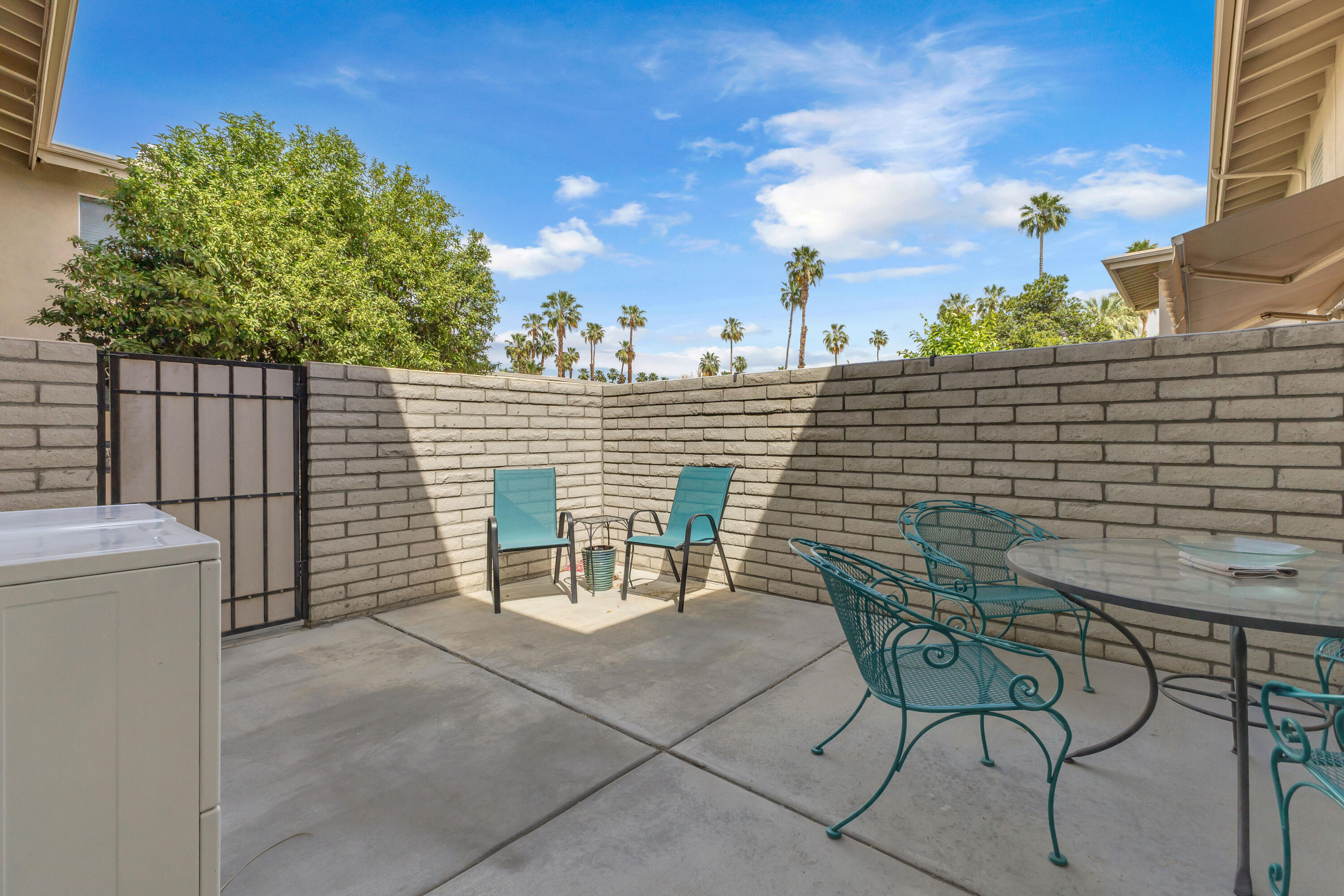 69850 Hwy 111 Rancho Mirage Ca, Unit 14 Rancho Mirage, CA 92270 - Photo 32 of 56 a view of a chairs and table in the back yard of the house