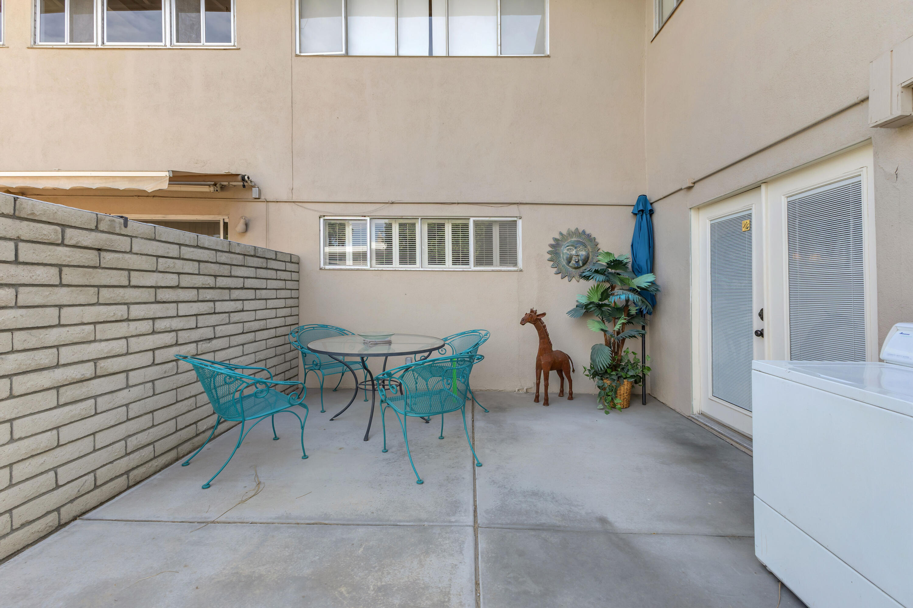 69850 Hwy 111 Rancho Mirage Ca, Unit 14 Rancho Mirage, CA 92270 - Photo 33 of 56 a view of a patio with table and chairs and potted plants