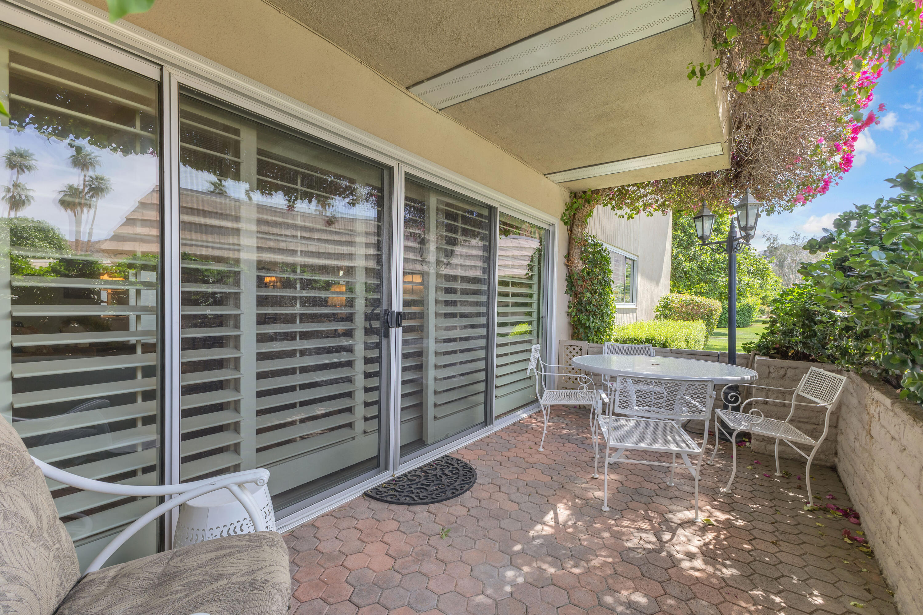 69850 Hwy 111 Rancho Mirage Ca, Unit 14 Rancho Mirage, CA 92270 - Photo 4 of 56 a view of a patio with a table and chairs and a barbeque
