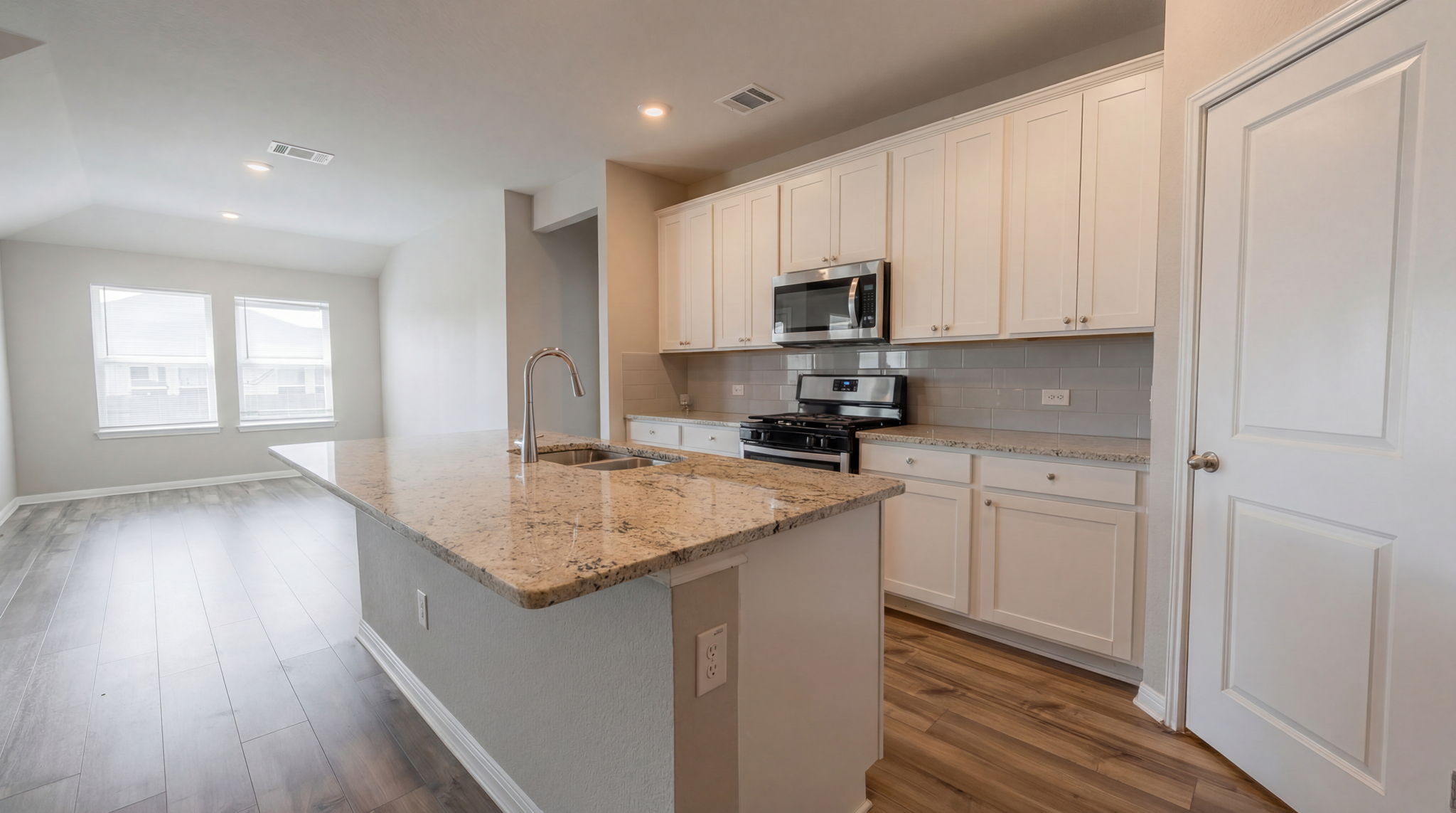 1003 Round Bale Road Hutto, TX 78634 - Photo 23 of 29 Kitchen with stainless steel appliances, light stone counters, a kitchen island with sink, dark wood-style floors, and backsplash