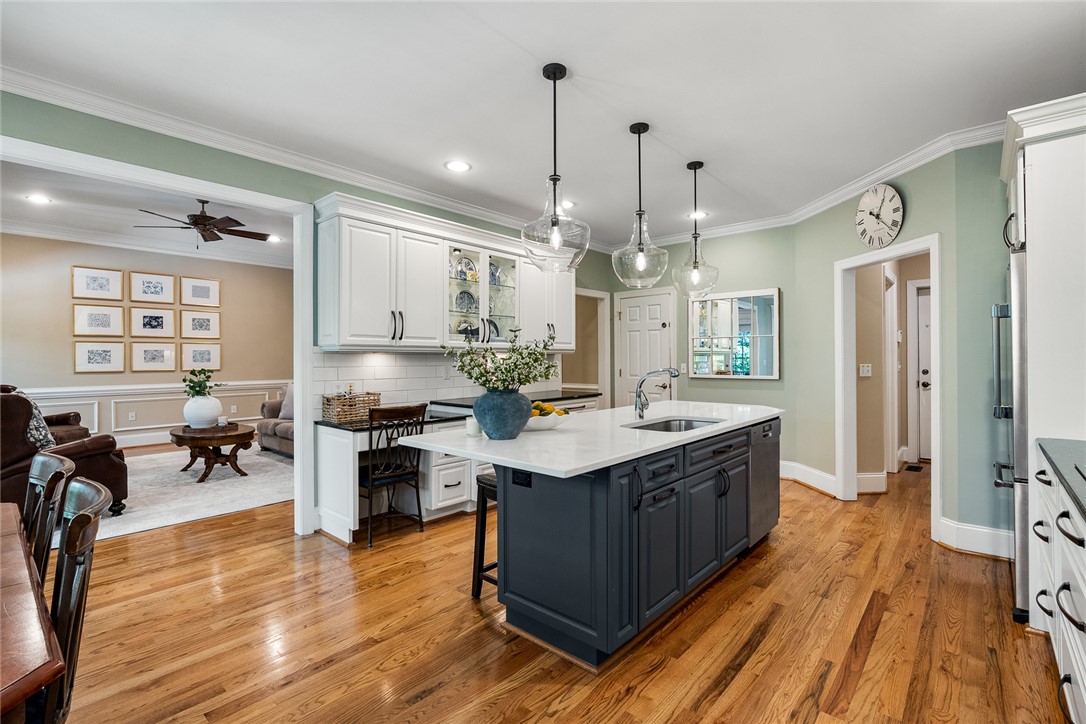 200 Graylyn Drive Anderson, SC 29621 - Photo 13 of 48 A well-appointed kitchen island with sleek pendant lights overlooks a cozy living area.