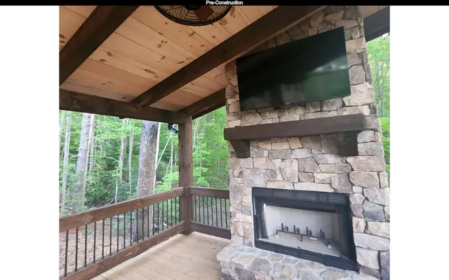 a living room with a fireplace a flat screen tv and a floor