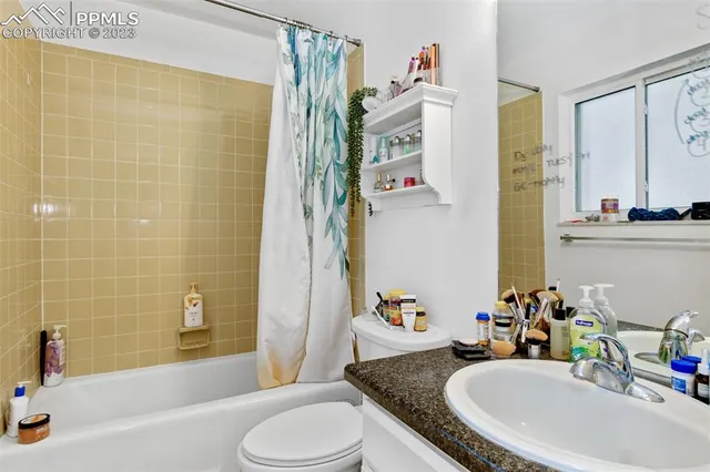 a bathroom with a granite countertop sink and a bathtub