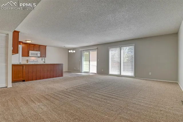 a view of an empty room with a kitchen
