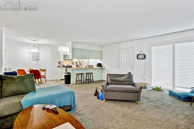 a living room with furniture and kitchen view