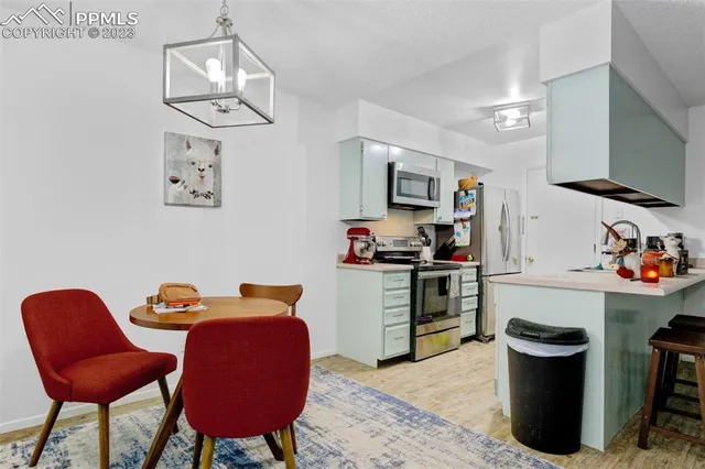 a kitchen with stainless steel appliances granite countertop a stove top oven a sink dishwasher and wooden cabinets with wooden floor