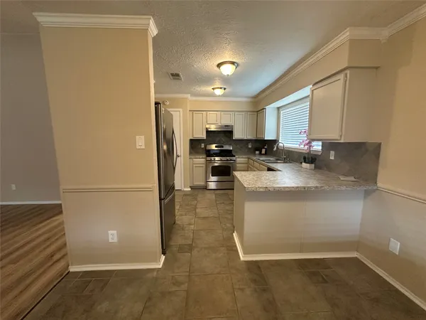 a kitchen with a sink a stove top oven and cabinetry