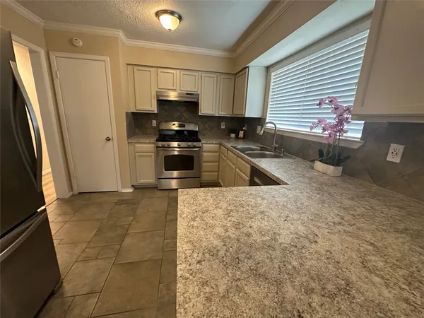 a kitchen with stainless steel appliances granite countertop a refrigerator and a sink