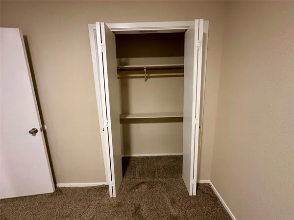 a view of an empty room with a fireplace and a window