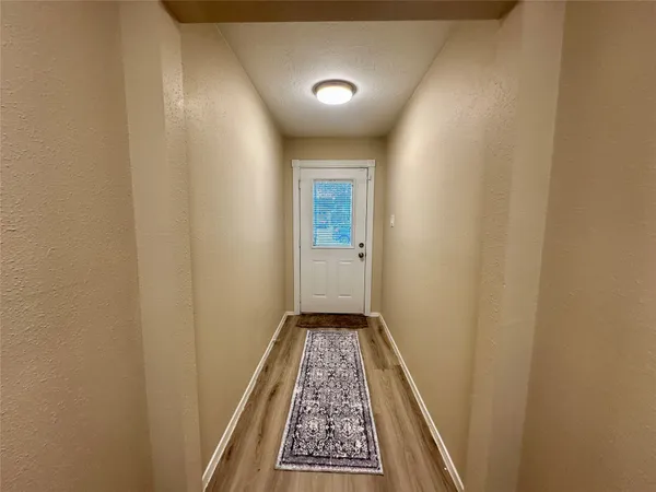 a view of an empty room with a fireplace and a window
