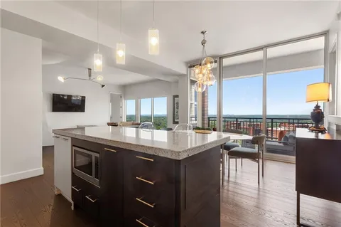 a kitchen with stainless steel appliances granite countertop a sink a stove and a wooden floors