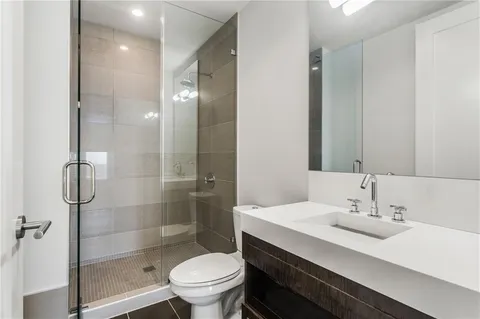 a bathroom with a sink a toilet and shower