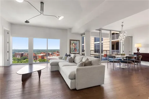 a living room with furniture wooden floor and a large window