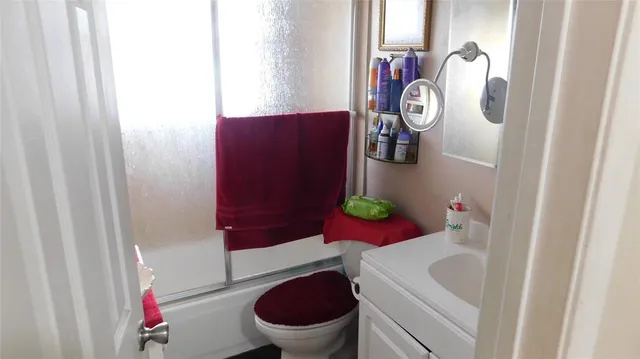 a bathroom with a sink vanity mirror and toilet